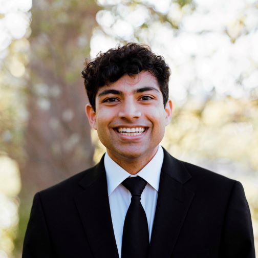 Dhruv Modi, MBID standing in front of tree trunk